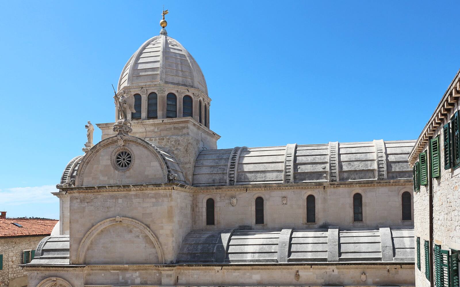 De stenen kathedraal van Sint-Jacobus in Šibenik met koepel en tongewelf onder een blauwe lucht