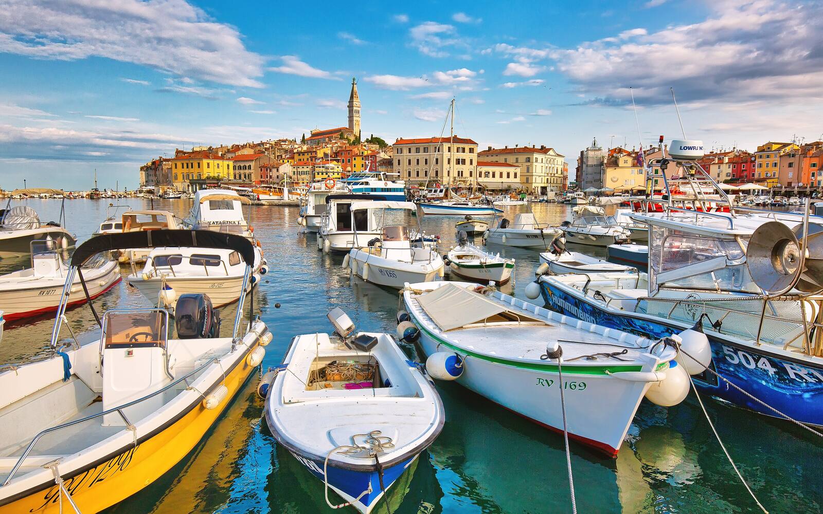 De oude stad van Rovinj met de klokkentoren van de kerk, gezien vanaf de jachthaven met bootjes op de voorgrond