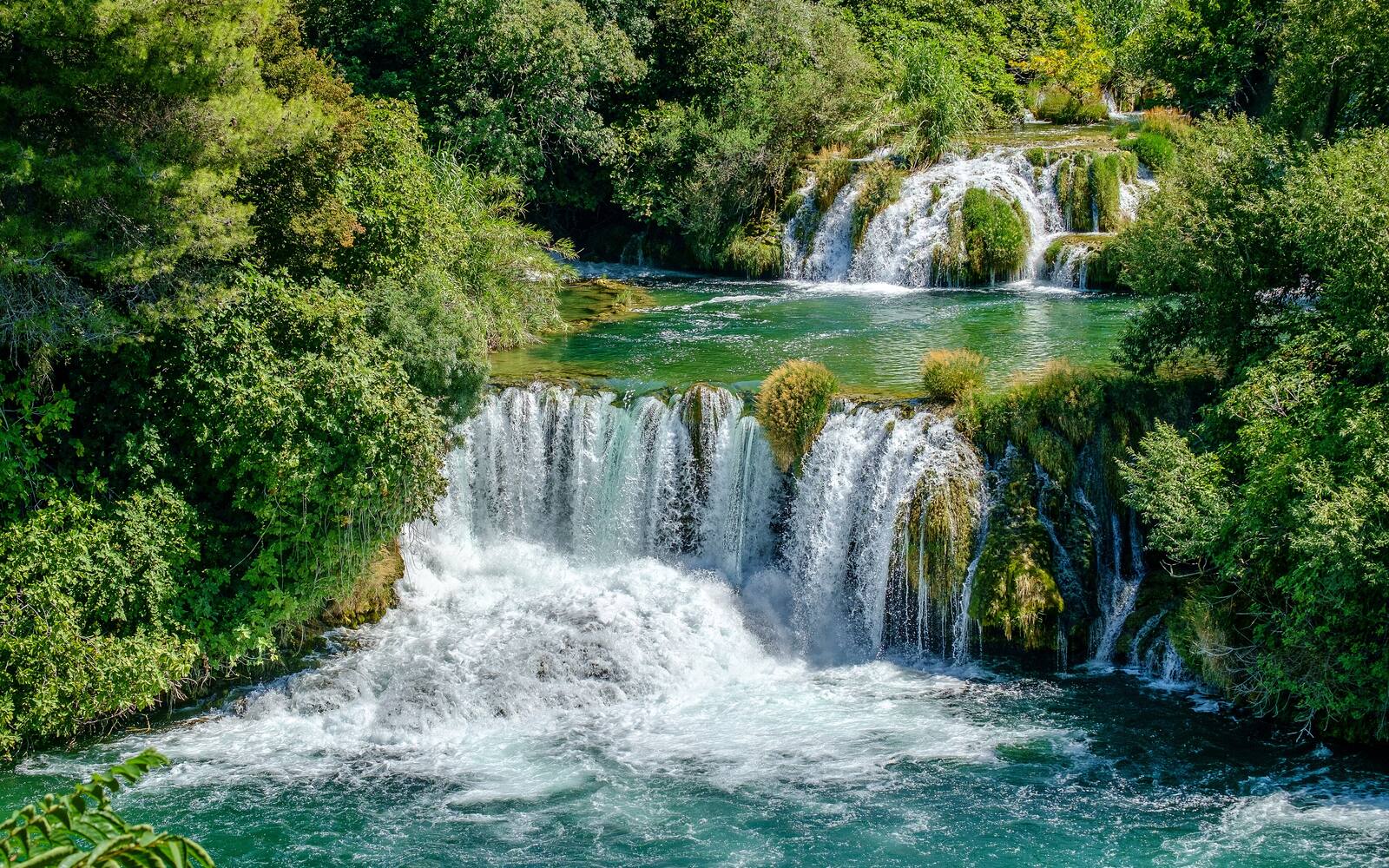 De watervallen van Skradinski buk in Nationaal Park Krka tussen groene bomen en turquoise water