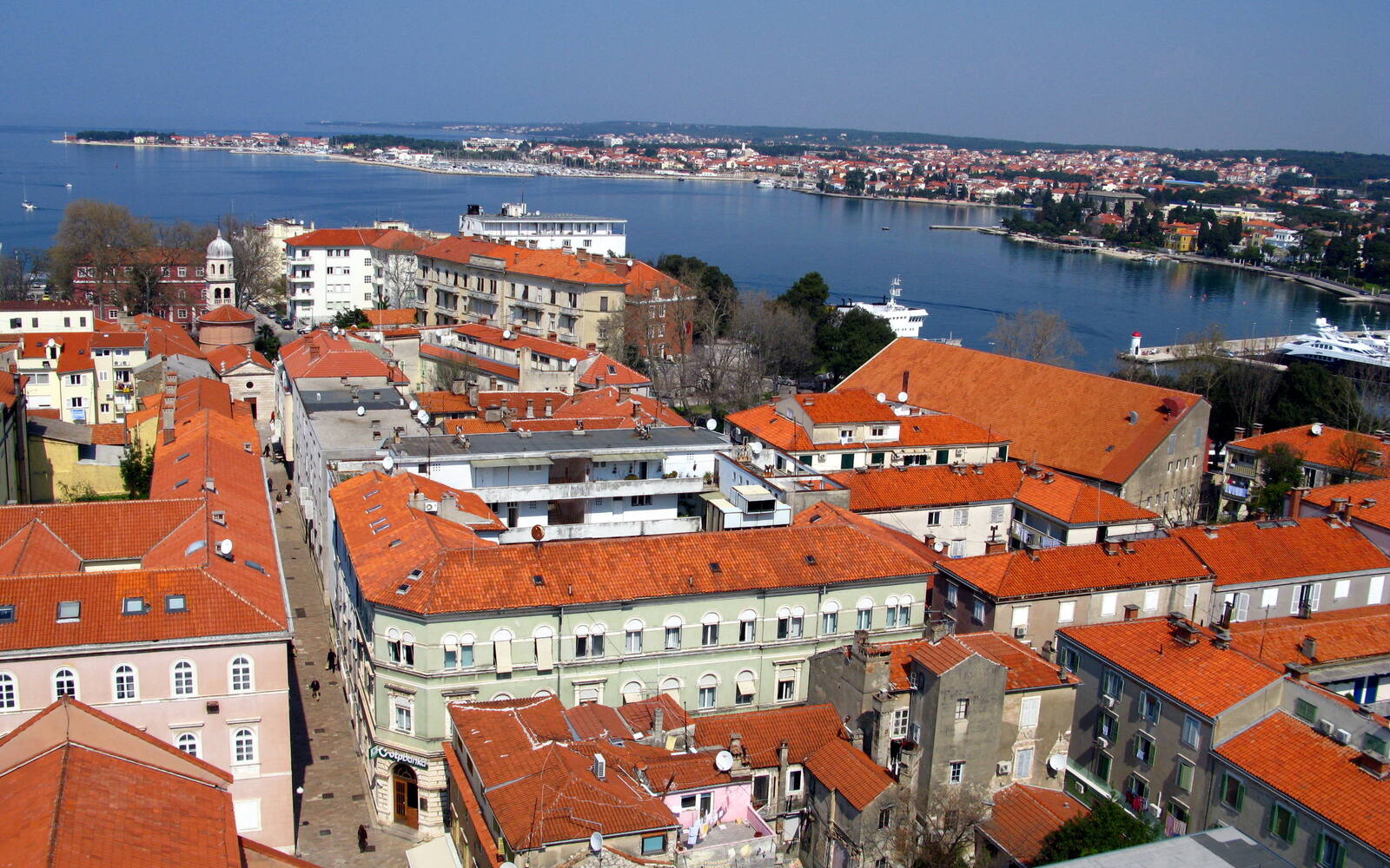 Uitzicht vanaf de klokkentoren over de rode daken van de oude stad van Zadar en de zee