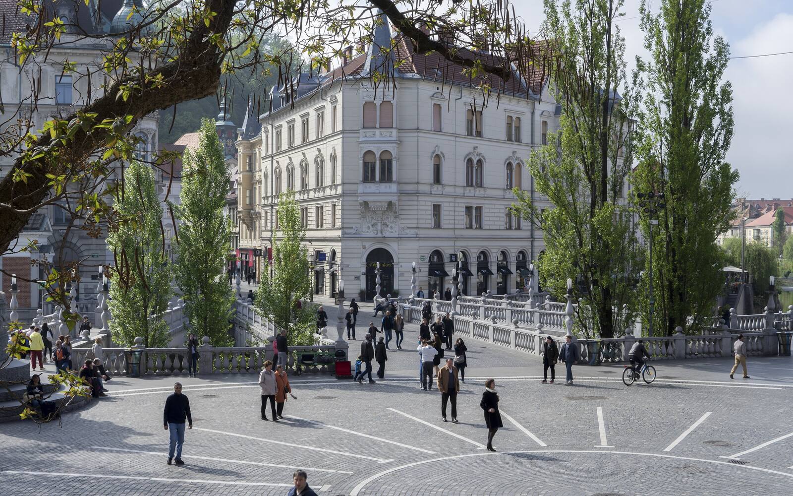 De Drievoudige Brug en het Prešerenplein in Ljubljana met statige gebouwen en wandelaars